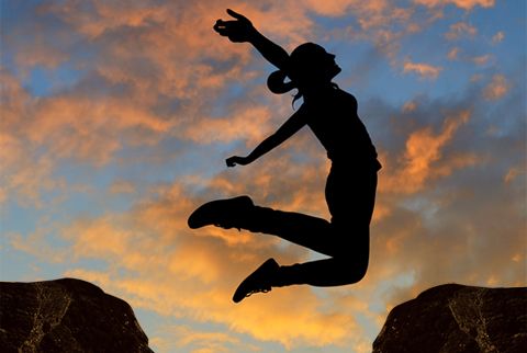 Picture of a women jump for a rock to another